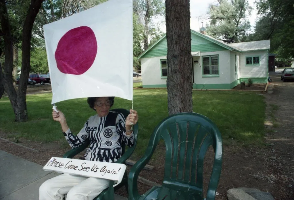 Mildred McCleave waits near Panorama Circle with a Japanese flag.